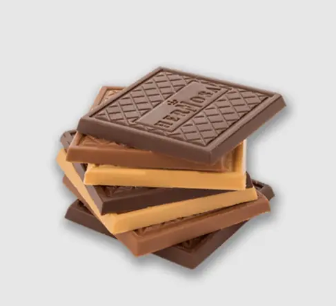 Milk chocolate pieces stacked on a wooden surface